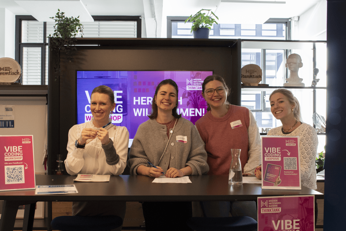 3 Frauen stehen am Einlass zum Vibe Coding Workshop