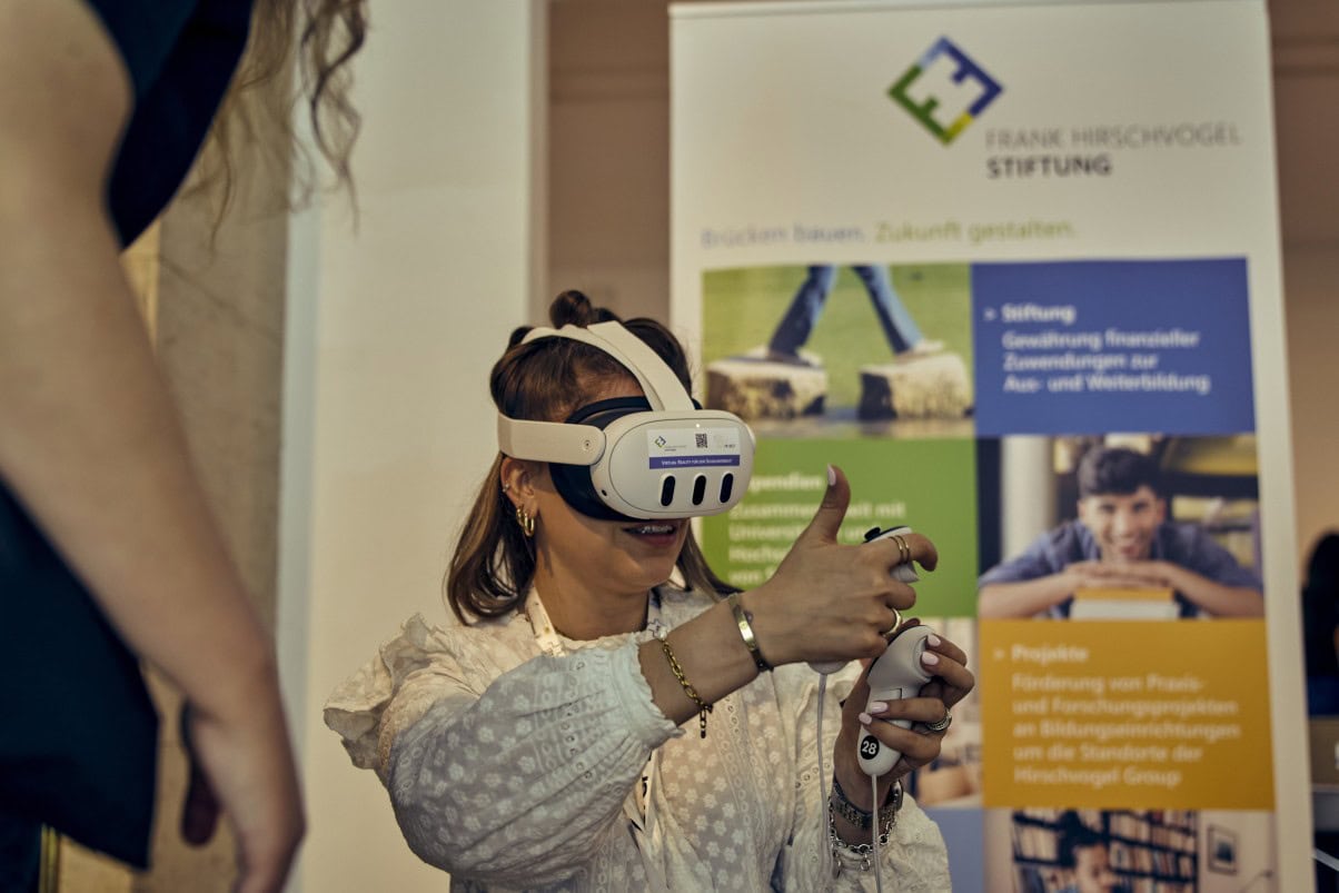 Eine junge Dame hat eine VR Brille an und probiert eine Anwendung aus